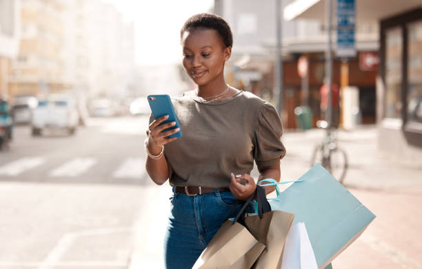 A shopper using her phone while moving through a city